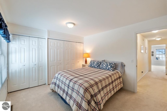 bedroom with two closets and light colored carpet