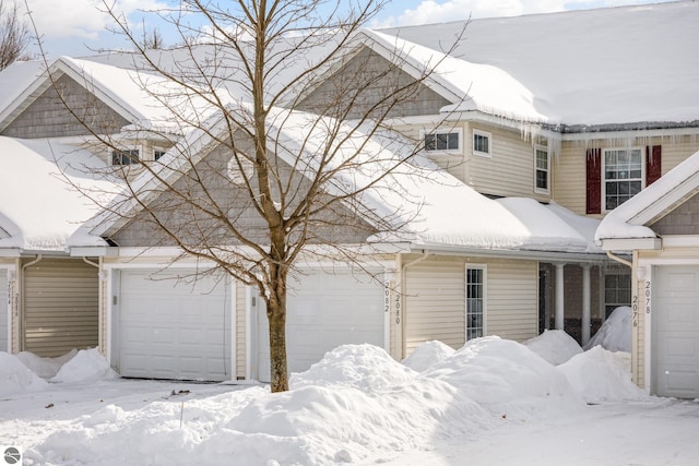 view of snow covered exterior with a garage