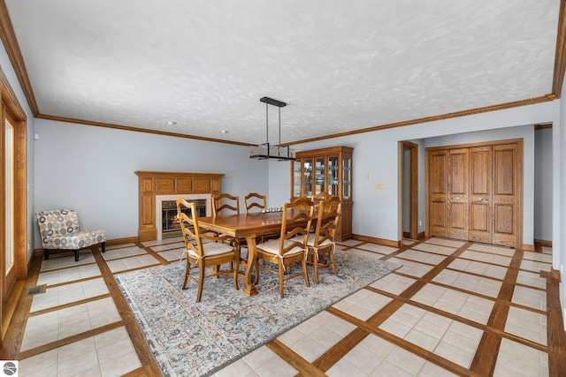 dining area with a notable chandelier, light tile patterned floors, ornamental molding, and a textured ceiling