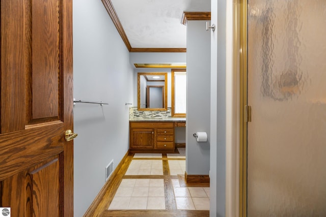 bathroom with crown molding, a shower with door, vanity, decorative backsplash, and tile patterned floors