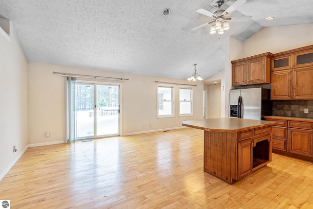 kitchen featuring a kitchen island, pendant lighting, stainless steel fridge, and light wood-type flooring