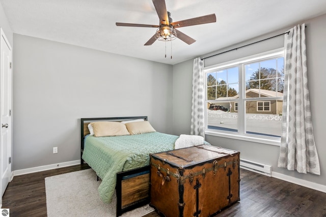 bedroom with ceiling fan, dark hardwood / wood-style floors, and a baseboard heating unit