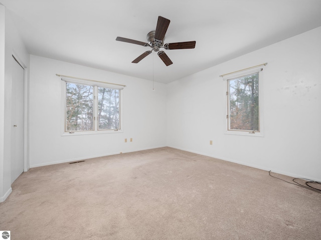 carpeted empty room featuring ceiling fan