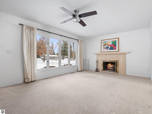 unfurnished living room featuring ceiling fan and carpet flooring