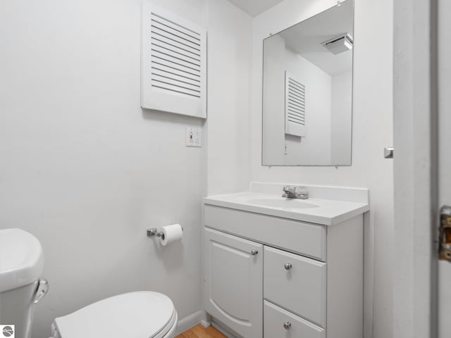 bathroom with vanity, hardwood / wood-style flooring, and toilet