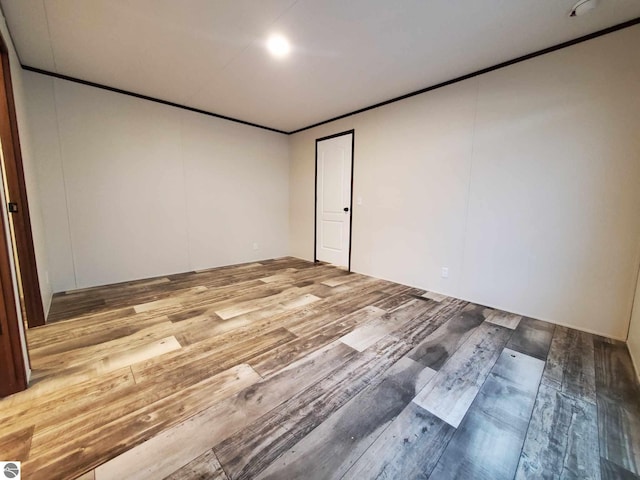 spare room with crown molding and light hardwood / wood-style flooring