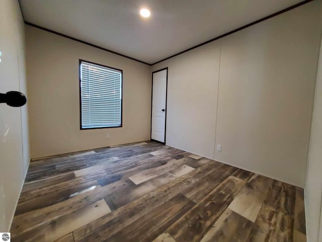 unfurnished room featuring crown molding and dark wood-type flooring