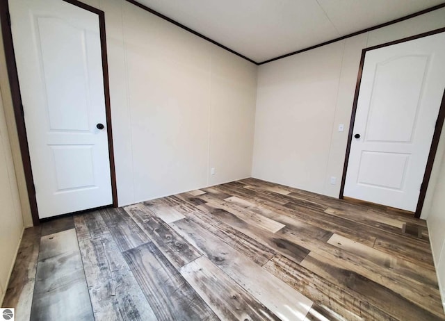 spare room featuring hardwood / wood-style flooring and ornamental molding