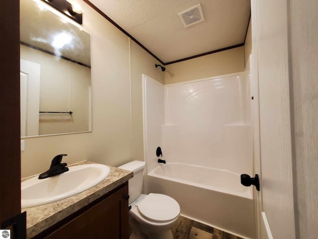 full bathroom featuring washtub / shower combination, vanity, toilet, and a textured ceiling