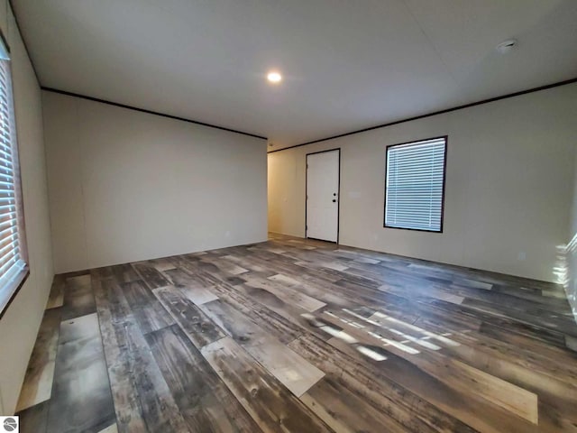 spare room with wood-type flooring and crown molding