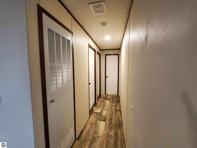 hall with hardwood / wood-style flooring and crown molding