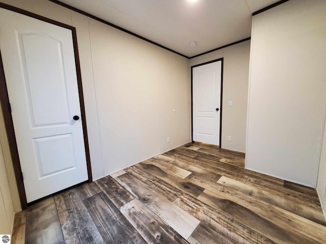 spare room featuring ornamental molding and dark hardwood / wood-style floors