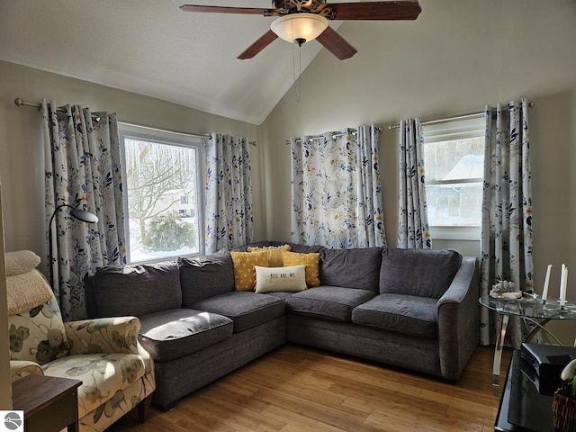 living room featuring ceiling fan, a healthy amount of sunlight, vaulted ceiling, and light wood-type flooring