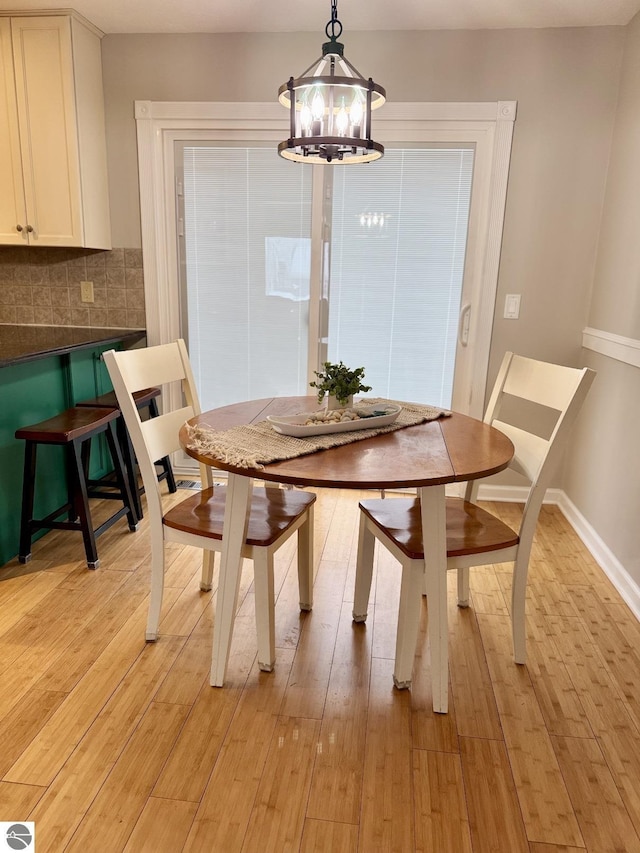 dining area with a chandelier and light hardwood / wood-style floors