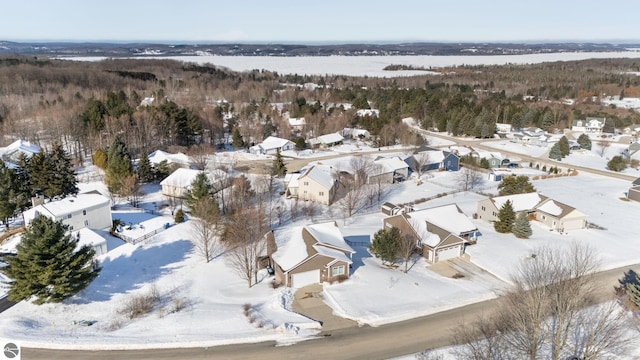 snowy aerial view with a forest view and a residential view