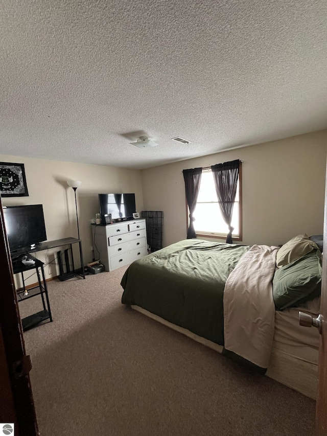 bedroom featuring carpet and a textured ceiling