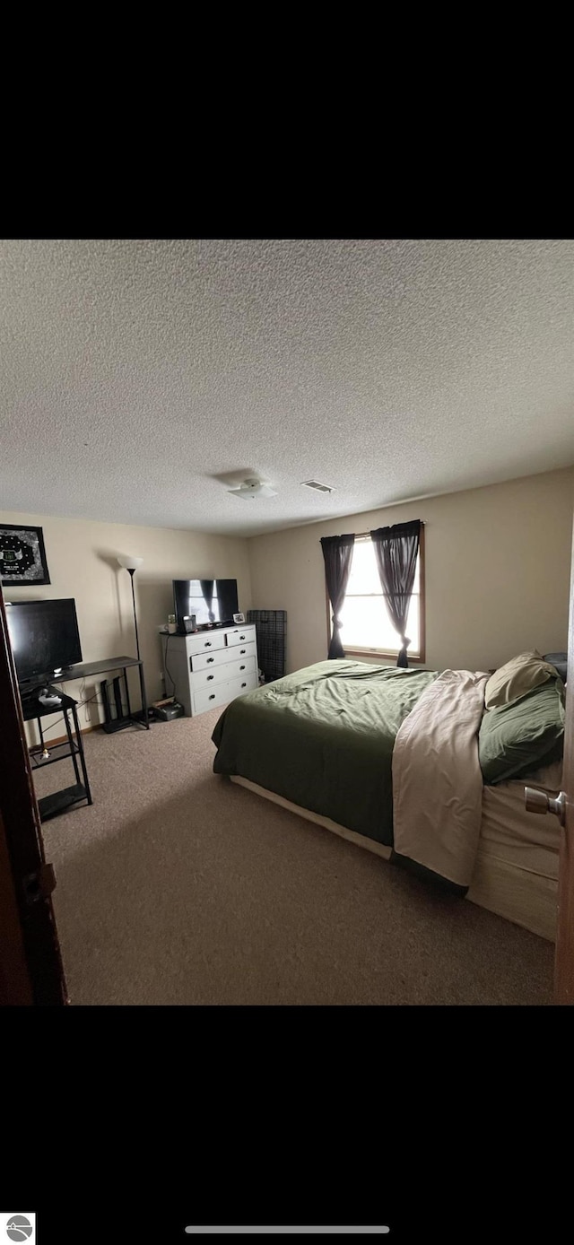 carpeted bedroom featuring a textured ceiling