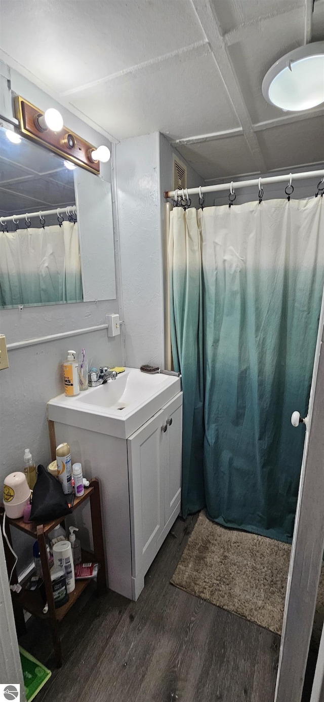 bathroom featuring hardwood / wood-style flooring, vanity, and curtained shower