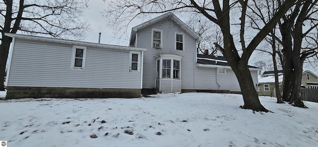 view of snow covered back of property