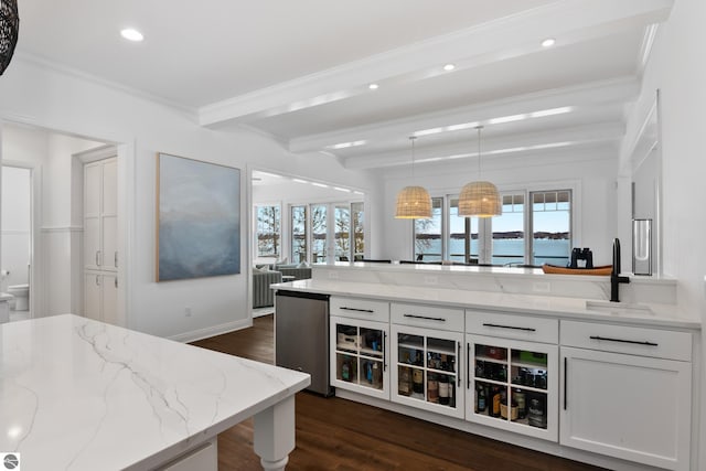 kitchen featuring sink, fridge, white cabinetry, beamed ceiling, and light stone countertops