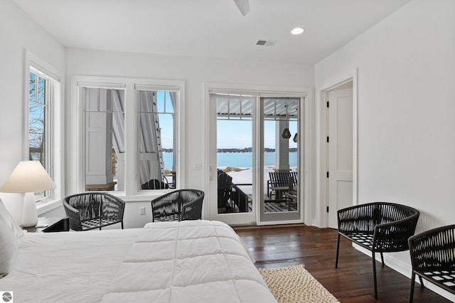 bedroom with a water view, access to exterior, and dark hardwood / wood-style floors