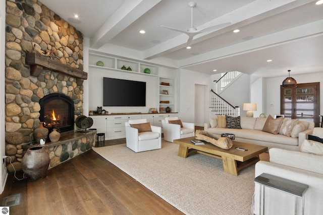 living room featuring a fireplace, hardwood / wood-style floors, beamed ceiling, and ceiling fan