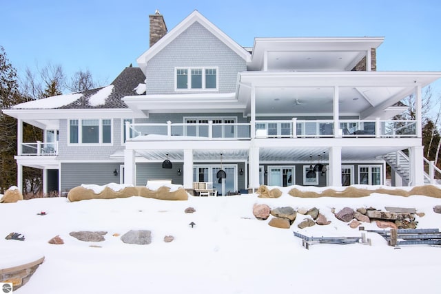 snow covered property with a balcony