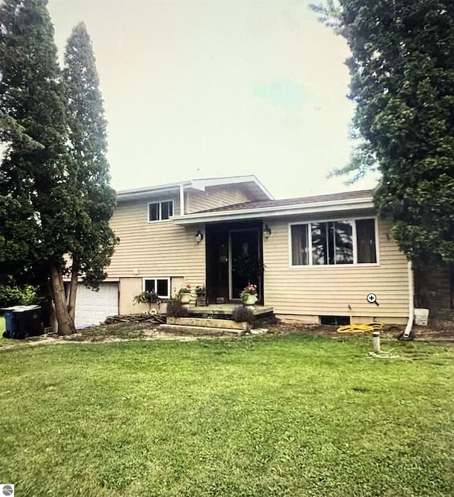 tri-level home with a garage and a front lawn