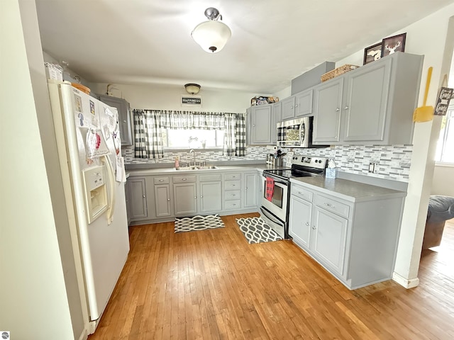 kitchen featuring stainless steel appliances, light hardwood / wood-style floors, sink, and plenty of natural light