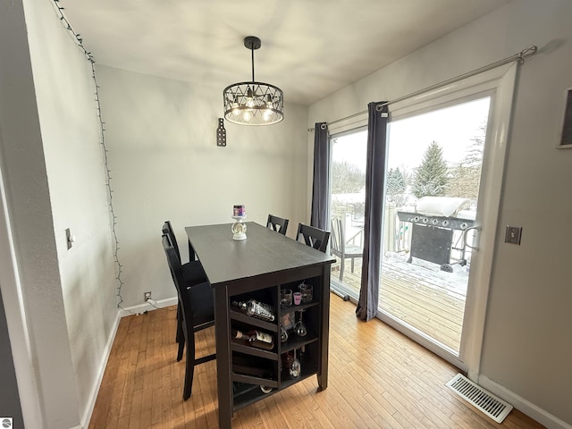 dining area with hardwood / wood-style flooring and a chandelier