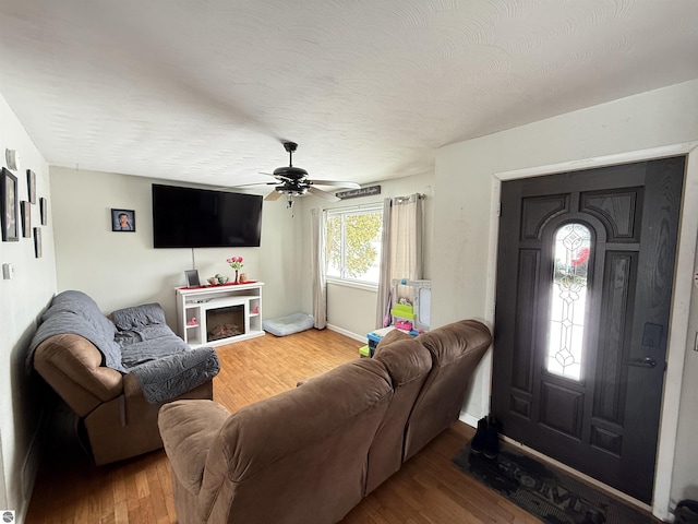 living room featuring ceiling fan, wood-type flooring, and a textured ceiling