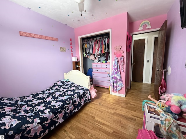 bedroom with ceiling fan, hardwood / wood-style floors, and a closet