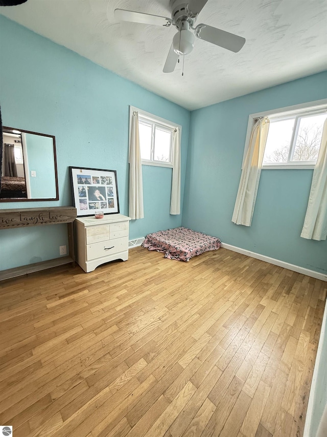 unfurnished bedroom with ceiling fan and light wood-type flooring