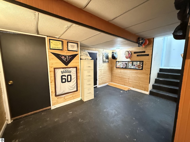 basement featuring wood walls