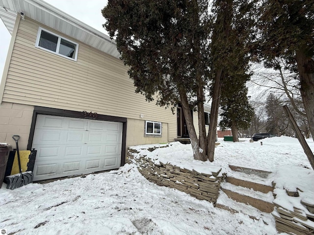 view of snowy exterior with a garage