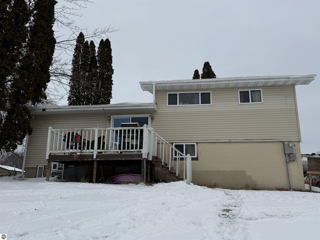 snow covered property with a wooden deck