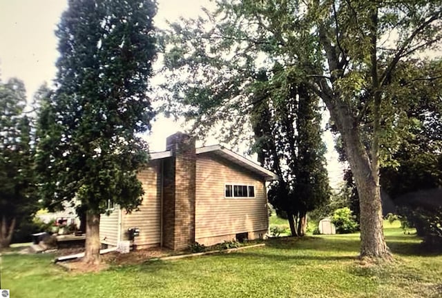 view of home's exterior with a storage shed and a lawn