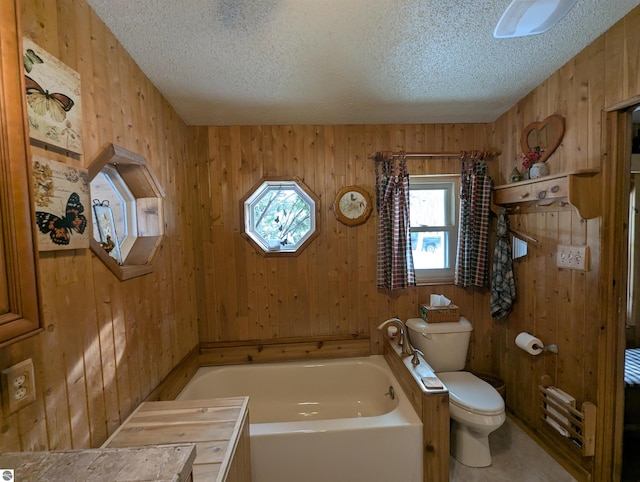 bathroom with a textured ceiling, wooden walls, a bathing tub, and toilet