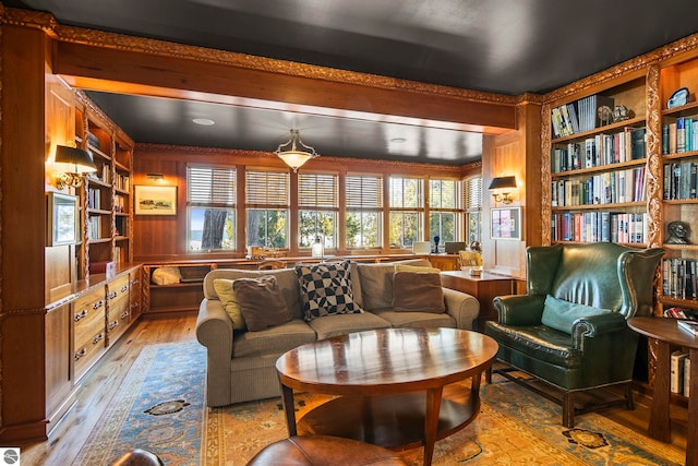 sitting room featuring built in shelves, plenty of natural light, and light hardwood / wood-style floors