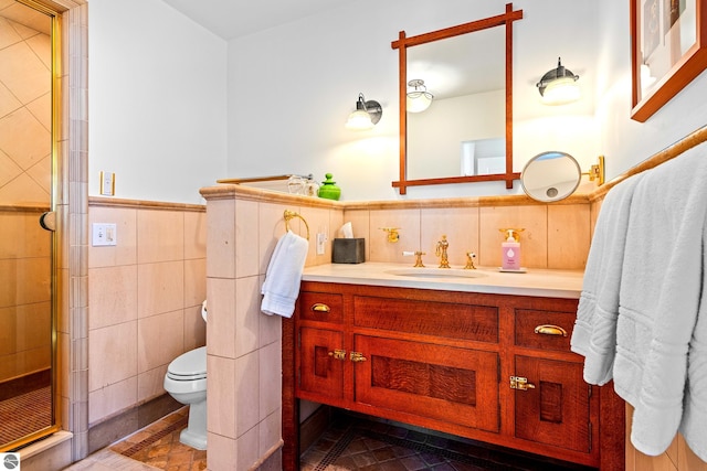 bathroom with walk in shower, vanity, toilet, and tile walls