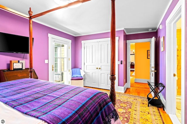 bedroom with ornamental molding, light hardwood / wood-style floors, and a closet