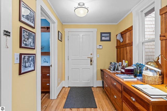 foyer featuring crown molding and light hardwood / wood-style floors