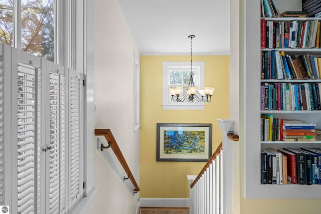stairway featuring baseboards and a chandelier