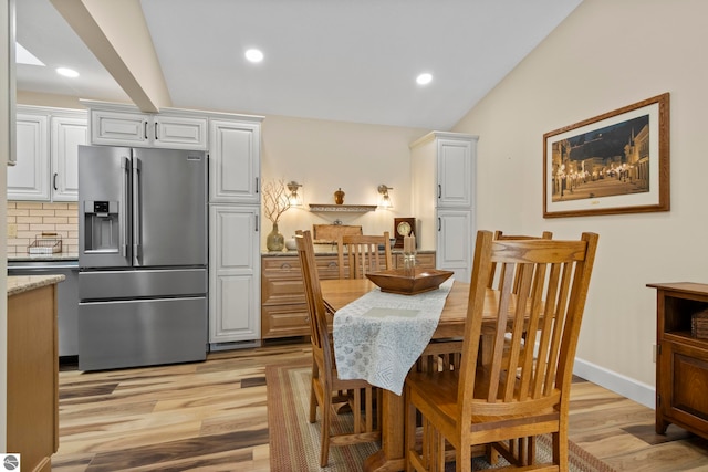 dining space featuring lofted ceiling and light hardwood / wood-style floors