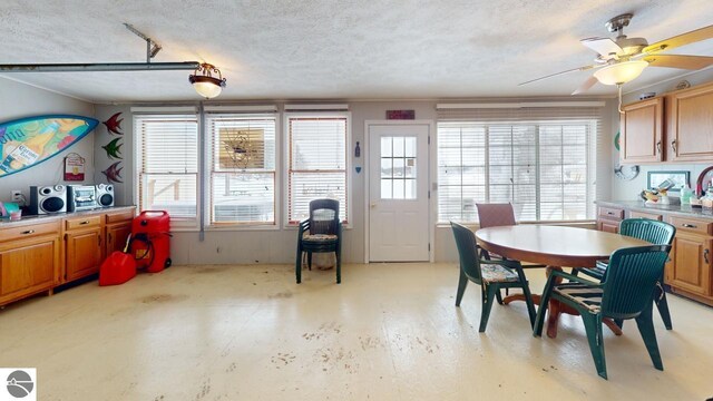 dining room featuring a ceiling fan and a textured ceiling