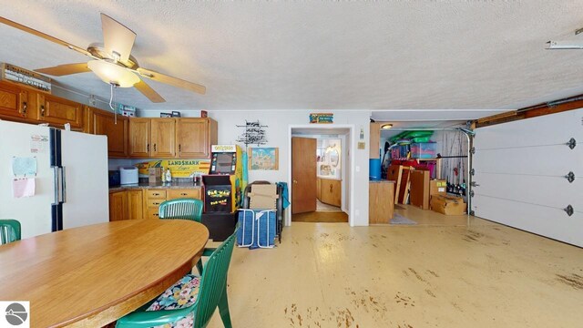 garage with ceiling fan and freestanding refrigerator