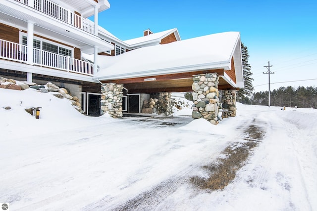 view of snowy exterior with a balcony