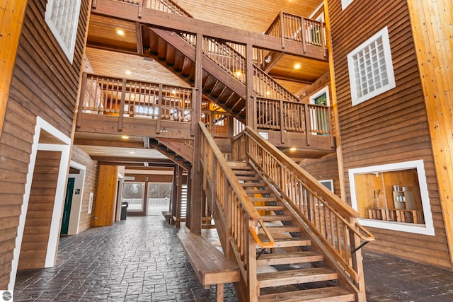 stairs featuring wood walls and a high ceiling