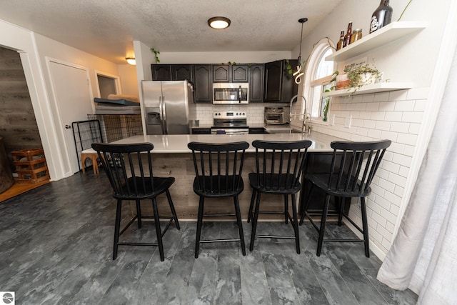 kitchen with a kitchen breakfast bar, stainless steel appliances, and kitchen peninsula