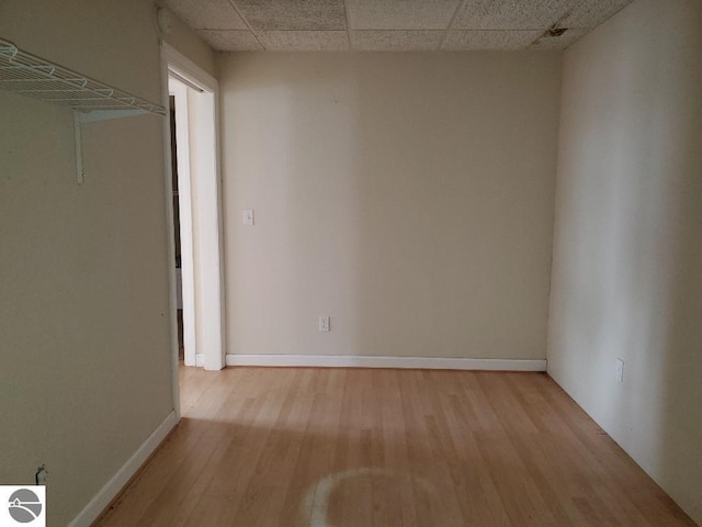 spare room featuring light hardwood / wood-style floors and a paneled ceiling